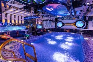 Blue-tiled indoor pool and surrounding lounge seating in a group room at Mr Spa, Hanoi.